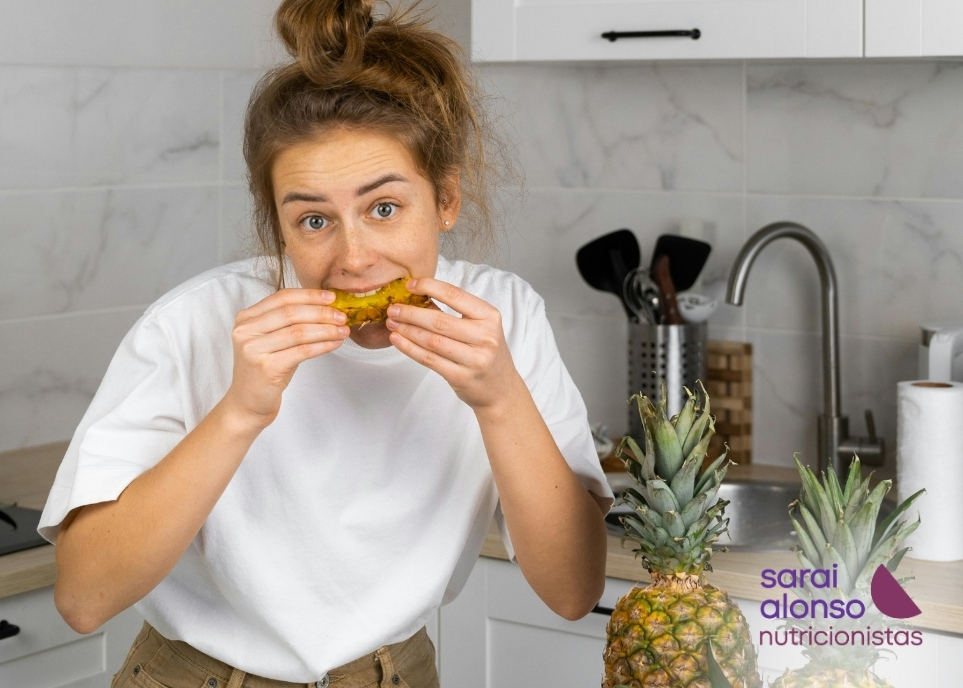 Mujer comiendo piña